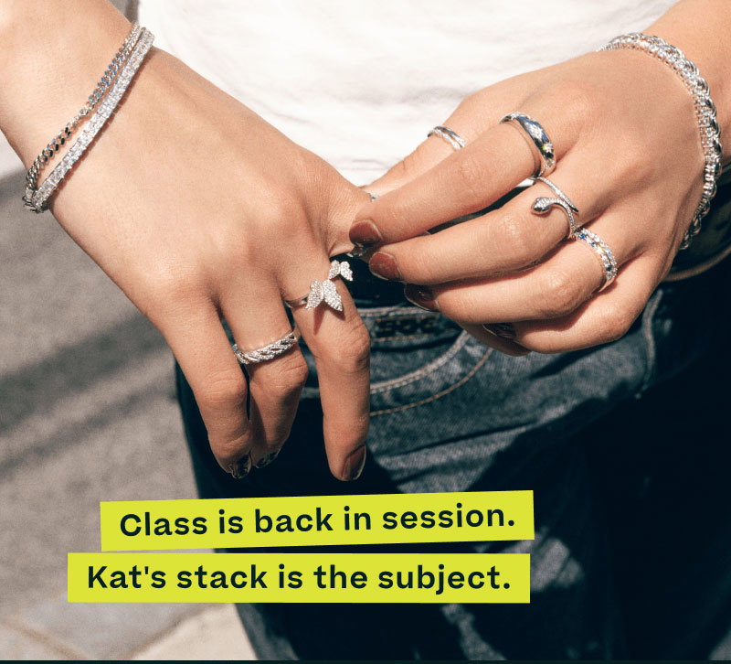Focus on hand with assortment of unique silver rings & bracelets. Class back in session. Kat’s stack is the subject.