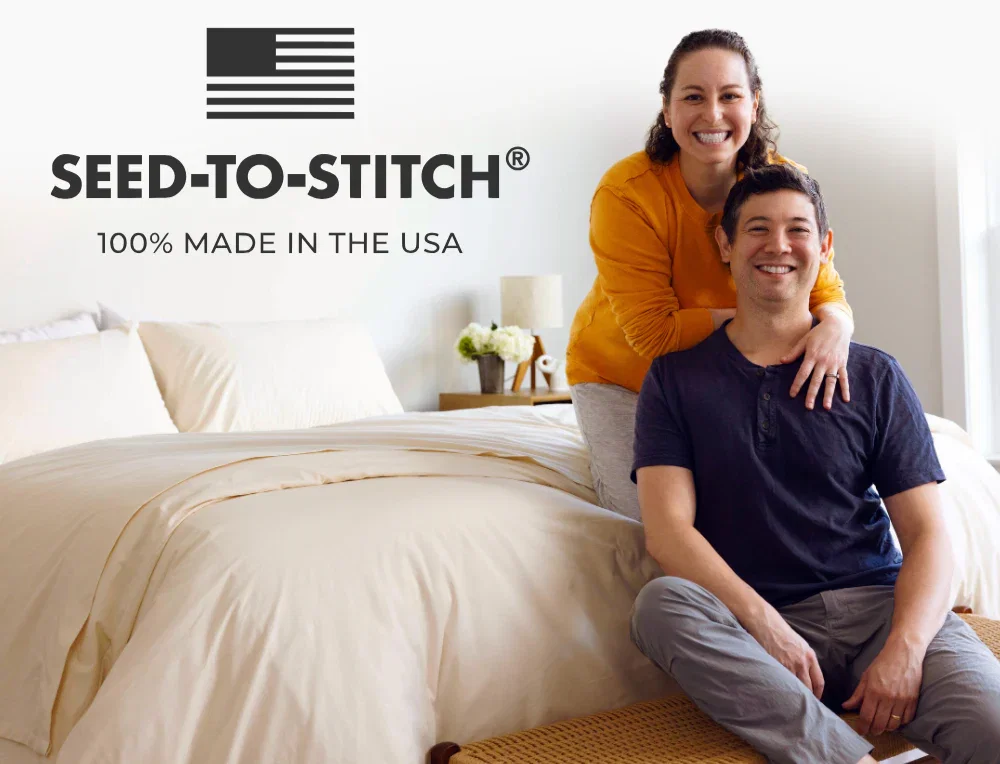 Picture of co-founders Steph & Jimmy sitting on a bed. All Authenticity50 products are 100% made in the USA from Seed-to-Stitch®.