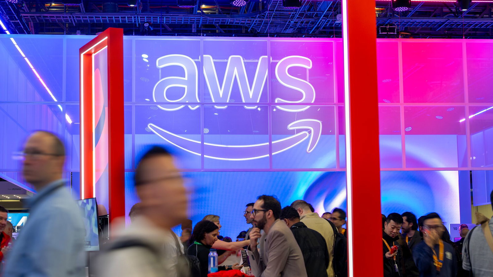 A busy crowd moves through an AWS exhibition space