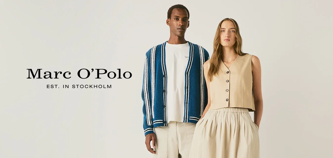Een man in lichte broek, wit hemd en blauw gestreepte cardigan staat naast een vrouw in een beige mouwloze top en lange rok met sneakers.