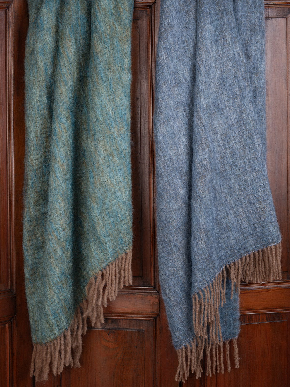 Barcelona. This luxurious Spanish-made throw, crafted from a mohair/wool/polyester blend, comes in rich Teal or delicate Periwinkle. They feature an elegant Gold-tone fringe for a refined touch.