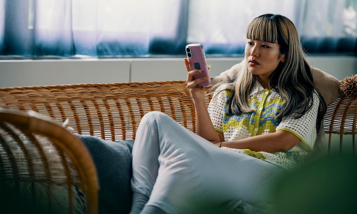 woman sitting on couch with phone