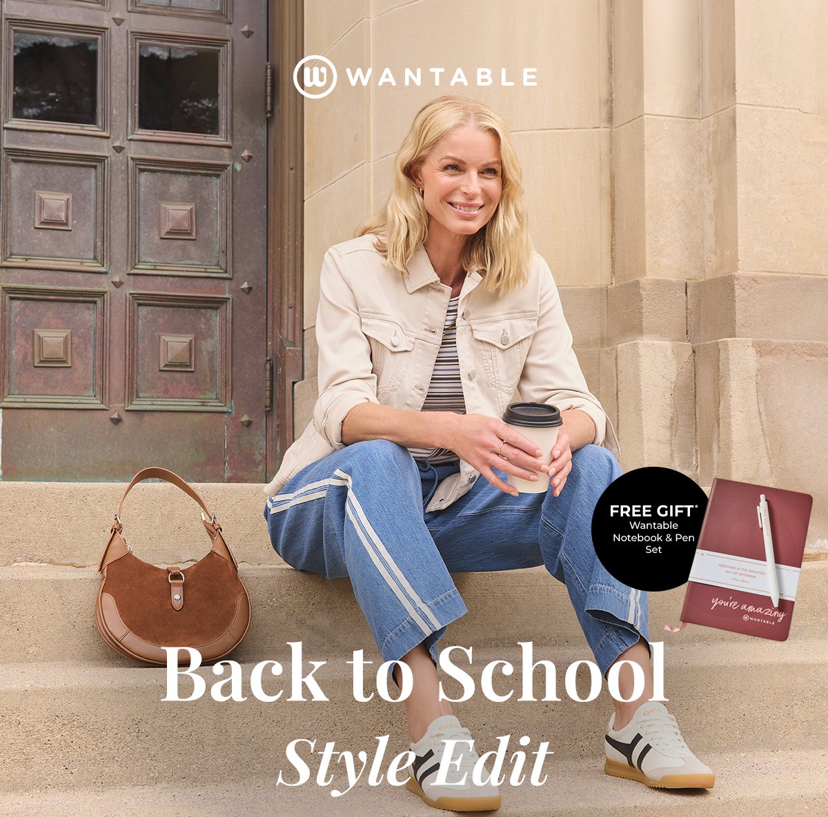 Woman in casual back to school outfit sits on stone steps holding a coffee.
