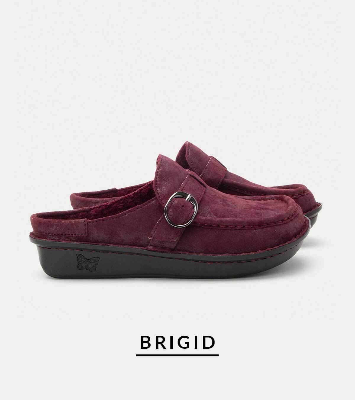 Pair of deep maroon suede slip-on mule shoes featuring a moc-toe design, plush inner lining, side strap with a metallic ring buckle, and a black platform sole. Product name "BRIGID" printed below.