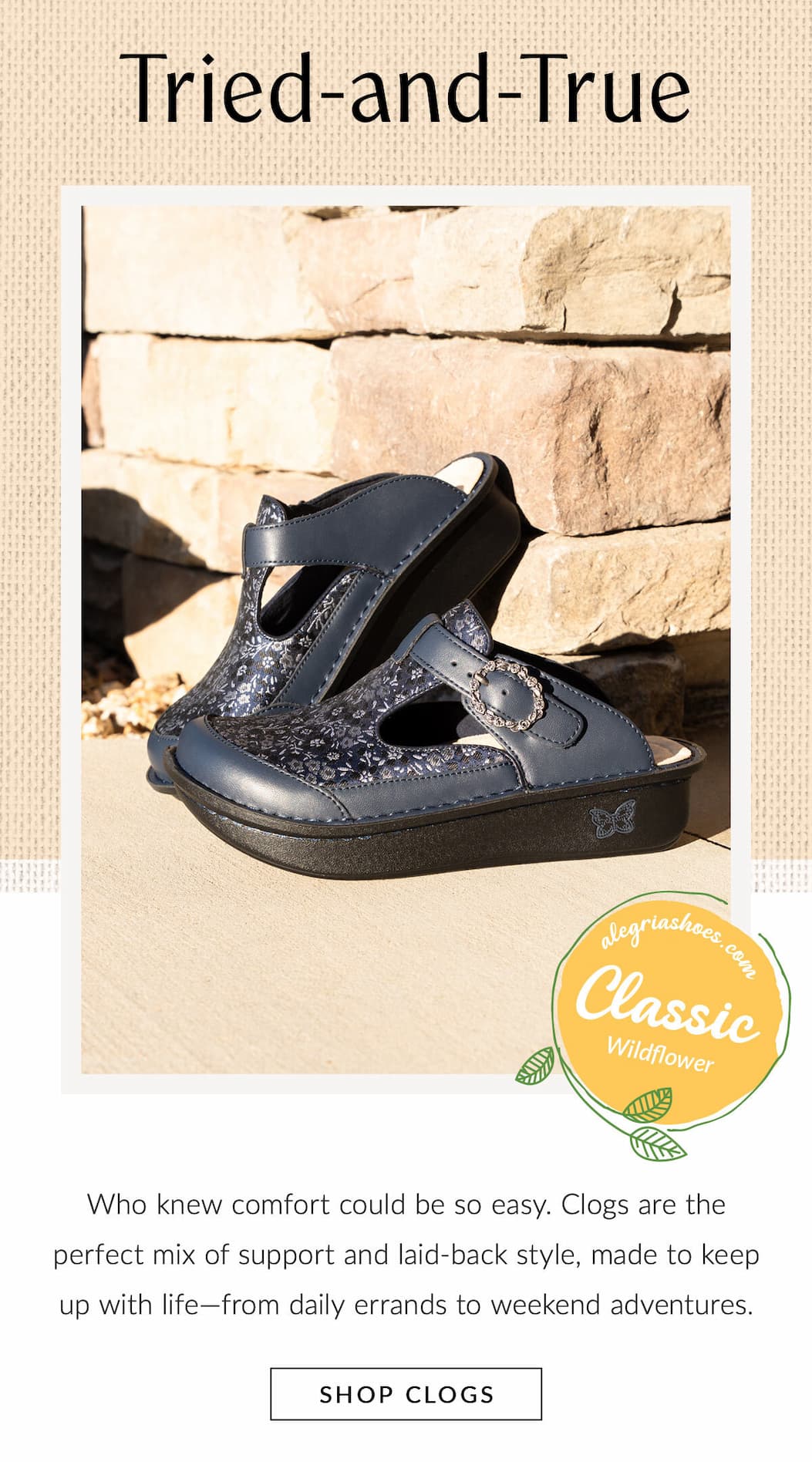 A pair of navy blue floral-patterned Alegria Classic Wildflower clog shoes resting against a stone wall background. Headline text reads "Tried-and-True" above with a "SHOP CLOGS" button featured at the bottom.