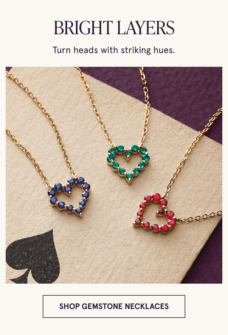 Three necklaces with heart shaped gemstone pendants rest on a playing card. Bright looks. Click to shop gemstone necklaces