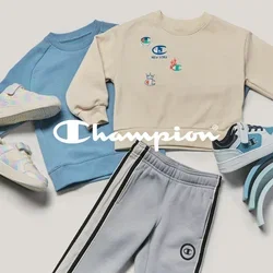Dos sudaderas infantiles, pantalones deportivos grises, tres pares de zapatillas deportivas y una pila de juguetes de madera con tonos azules en forma de arcoíris sobre un fondo beige.