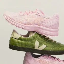 Dos zapatillas rosas y dos zapatillas verdes con logotipos blancos están apiladas alternativamente en una disposición vertical equilibrada sobre un fondo liso.
