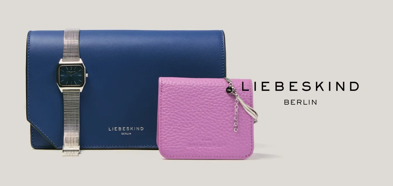 Cartera de mano de cuero azul con un reloj de pulsera plateado encima, y un pequeño monedero rosa texturizado con cremallera plateada.