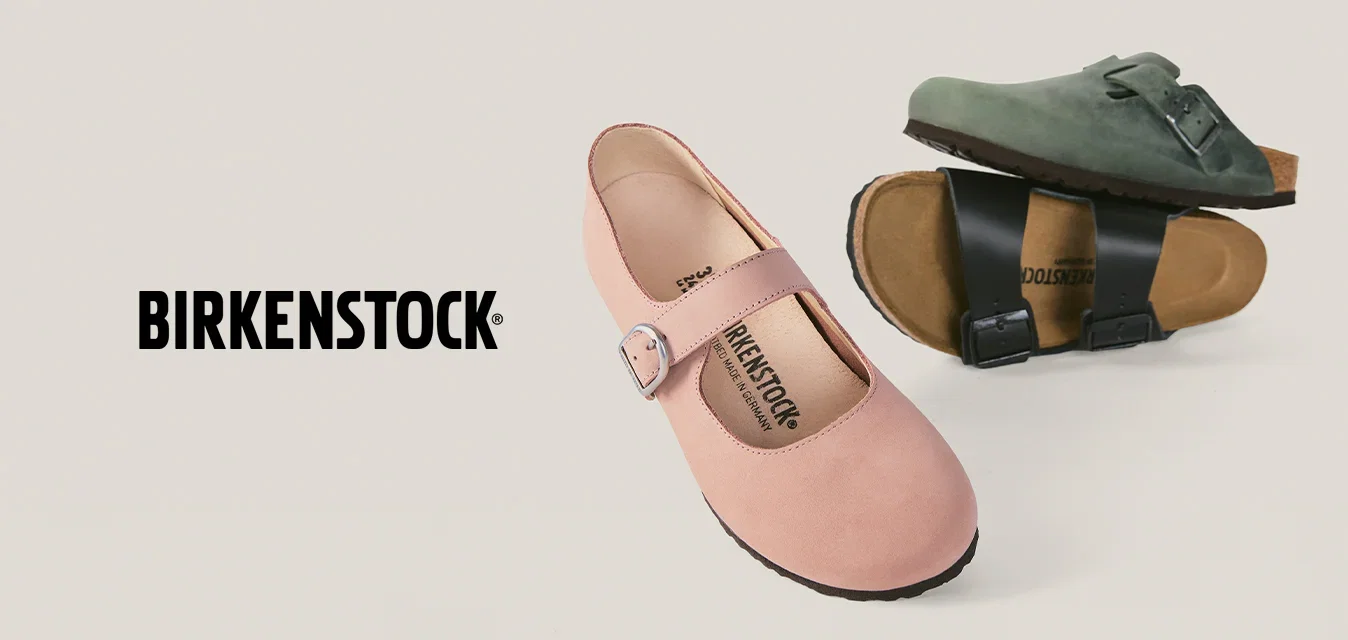 Zapato Mary Jane rosa con hebilla y dos sandalias Birkenstock en verde y negro con correas con hebilla sobre fondo beige.