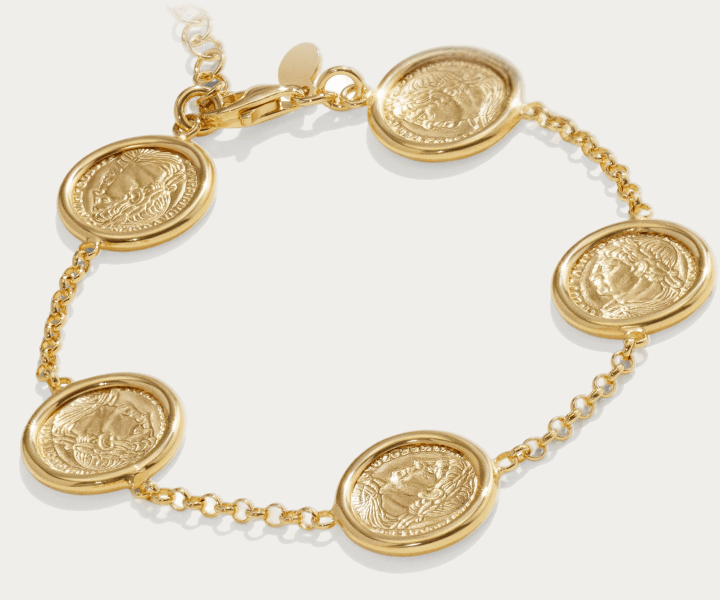 A gold bracelet with engraved coin charms and chain links.