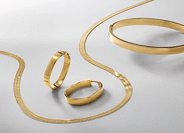 A gold necklace, earring and bracelet set. A gold necklace with floral charms. A gold butterfly necklace, ring and earring set.