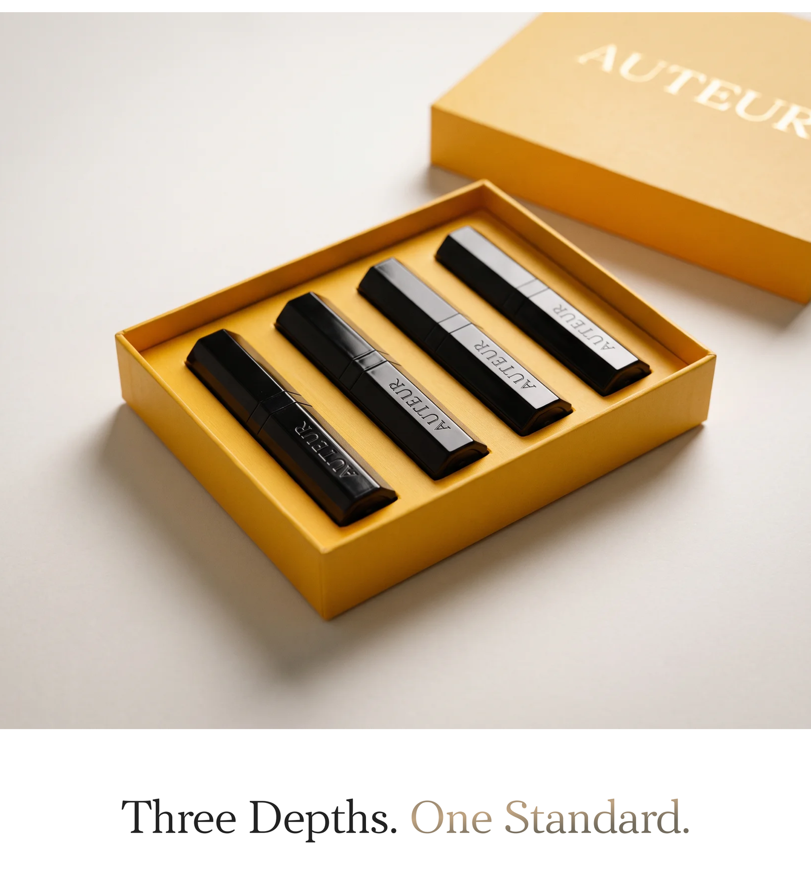 Open mustard-yellow Journey Discovery Kit box with four black travel-size vials on a white surface, headline 'Three Depths. One Standard.' below