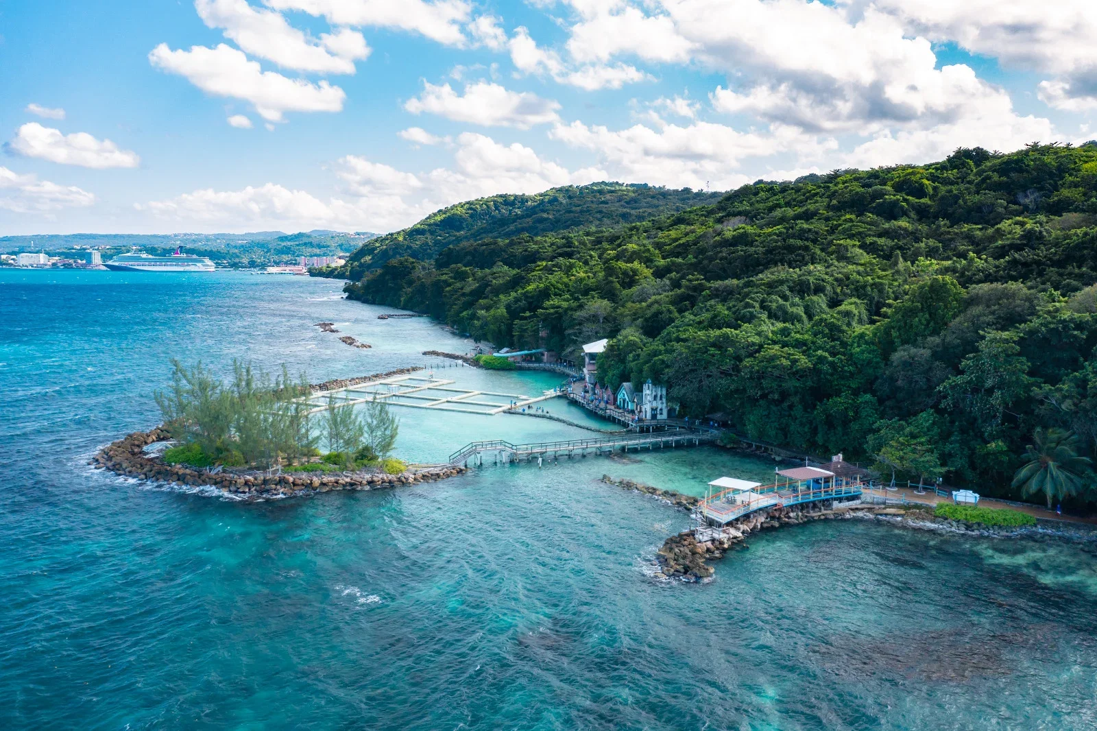 Aerial view of Dolphin Cove in Ocho Rios, Jamaica, where turquoise Caribbean waters meet a lush green tropical coastline