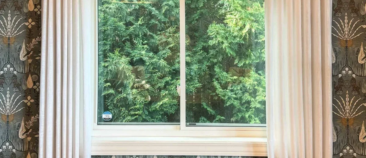 Custom woven wood shades and drapery styled in a dining room