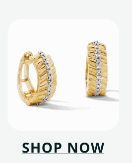 Gold-tone huggie hoop earrings with clear pavé stones across the front and polished sides. Click here to shop now