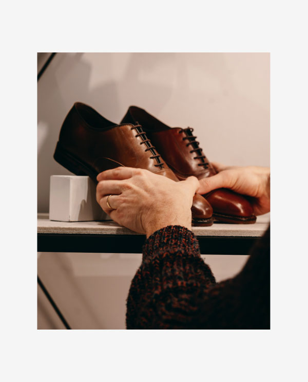 Image Of Store Expert Putting A Pair Of Park Avenue Shoes On A Store Shelf.