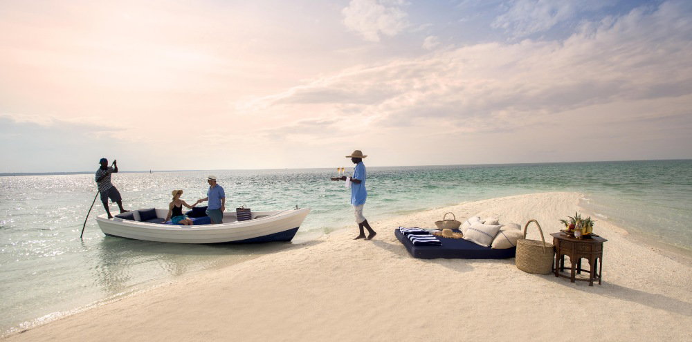 Couple arrives by boat for a private beach picnic on Benguerra Island