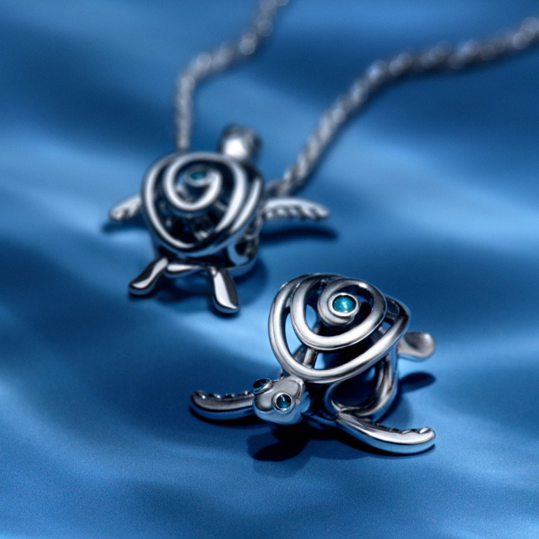 Blue manta ray and octopus Pandora Moments charms on a blue background.
