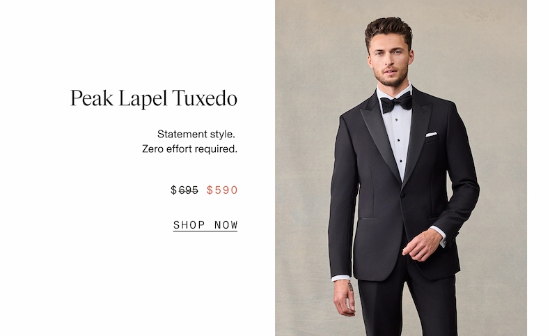 Man wearing a black peak lapel tuxedo with a black bow tie, white dress shirt, and white pocket square, standing with one hand tucked into his jacket. Peak Lapel Tuxedo. Statement style. Zero effort required. $695 $590 SHOP NOW