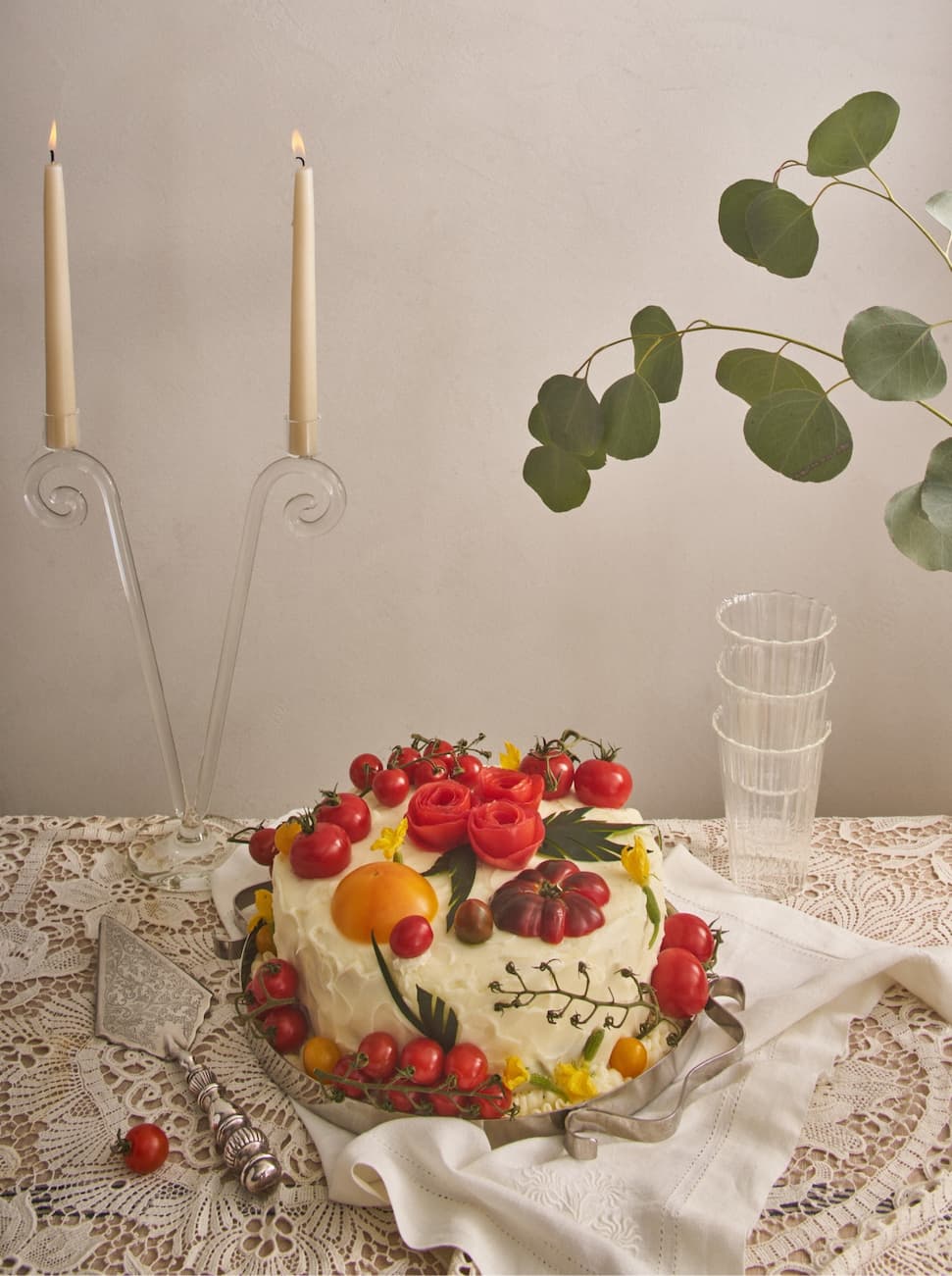 A cake dressed in tomatoes, served on a silver tray 