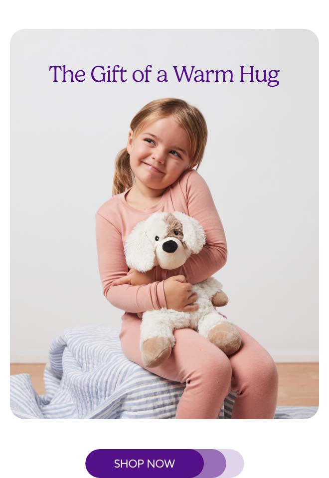A little girl hugging Puppy Warmies. Shop Now.
