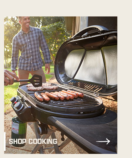 Person grilling burgers and sausages outdoors on a barbecue. Shop cooking button in lower left corner.
