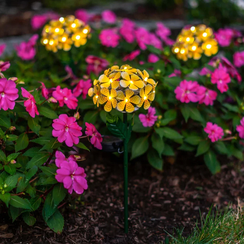 Bright yellow solar flower lights among vibrant pink blooms in a garden setting, promoting eco-friendly outdoor decor.