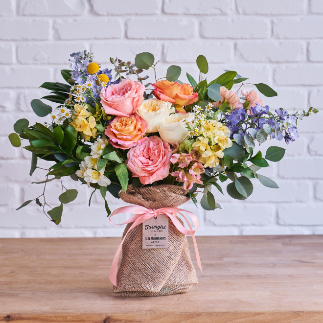 Peach roses, yellow flowers, and blue delphinium in burlap wrap. With Heart: Love Thy Neighbor, Fun Size. Shop now.
