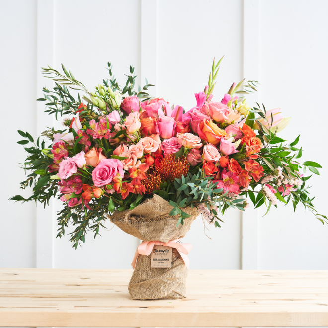 A full pink, coral, and orange arrangement in burlap wrap. Hand Tied Bouquet, Fancy Pants Size. Shop now.