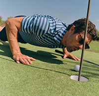 Man in blue striped polo on golf course.