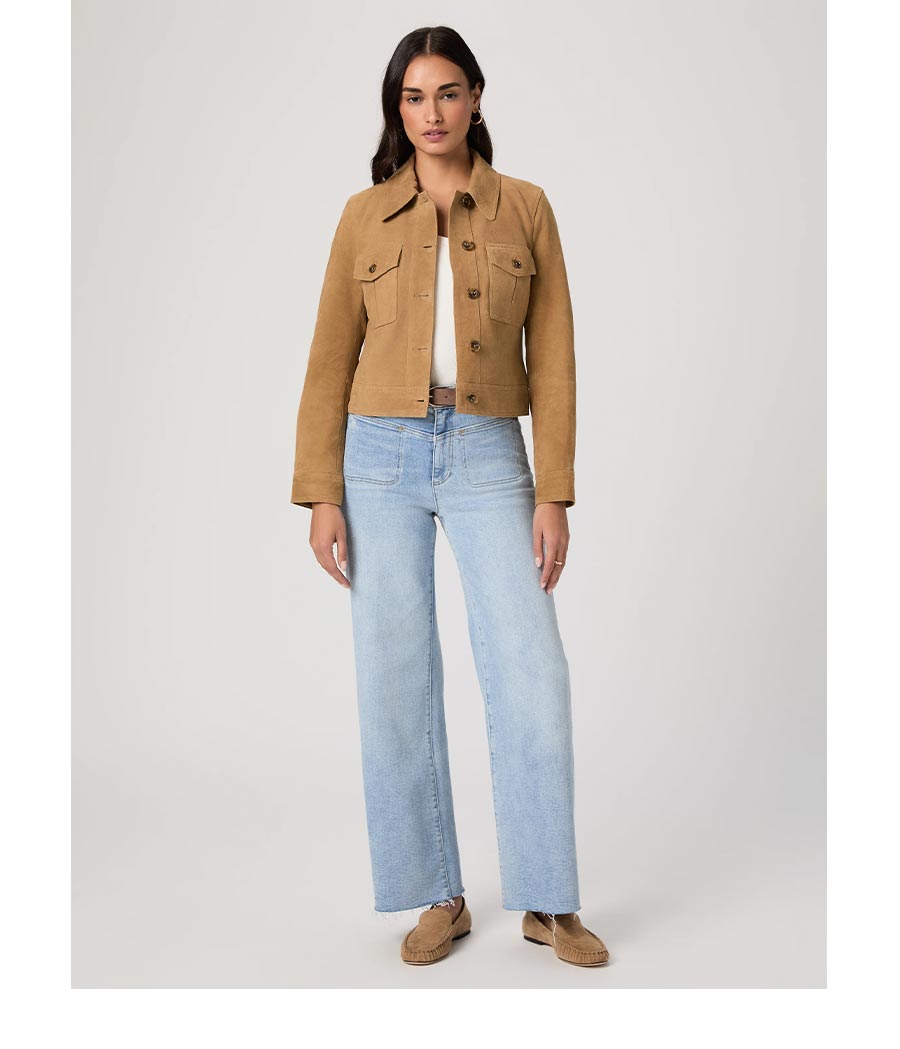 Woman wearing a cashew brown suede collared jacket over a white tee and a high rise wide leg light wash jeans