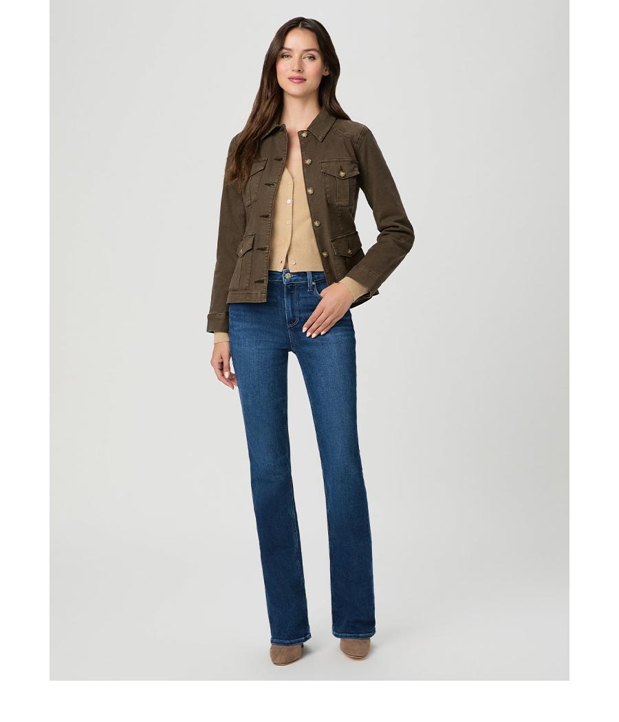Woman wearing a dark green utility jacket over a beige cardigan and high rise flare dark wash jeans