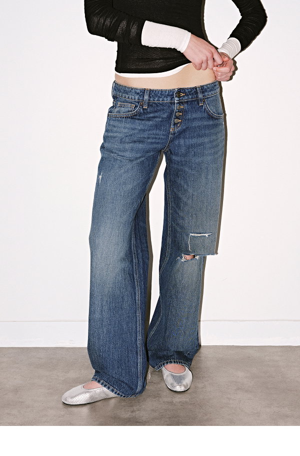 Woman wearing distressed blue jeans and black crop top