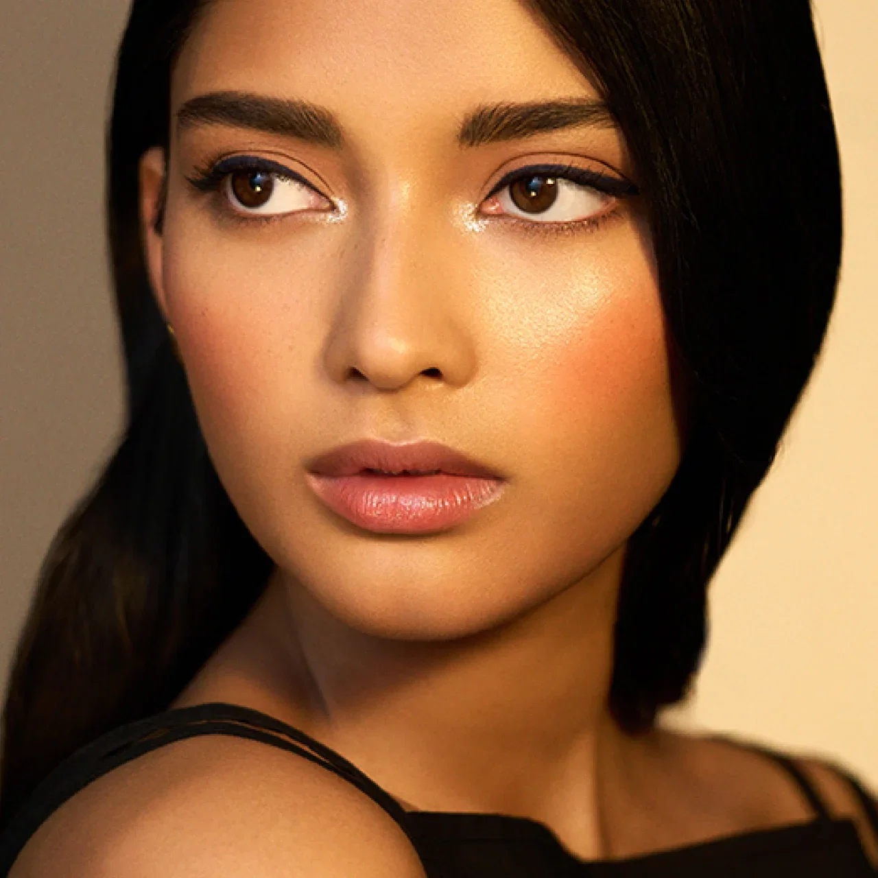 Close-up of a woman face showing a glowing night-out look.
