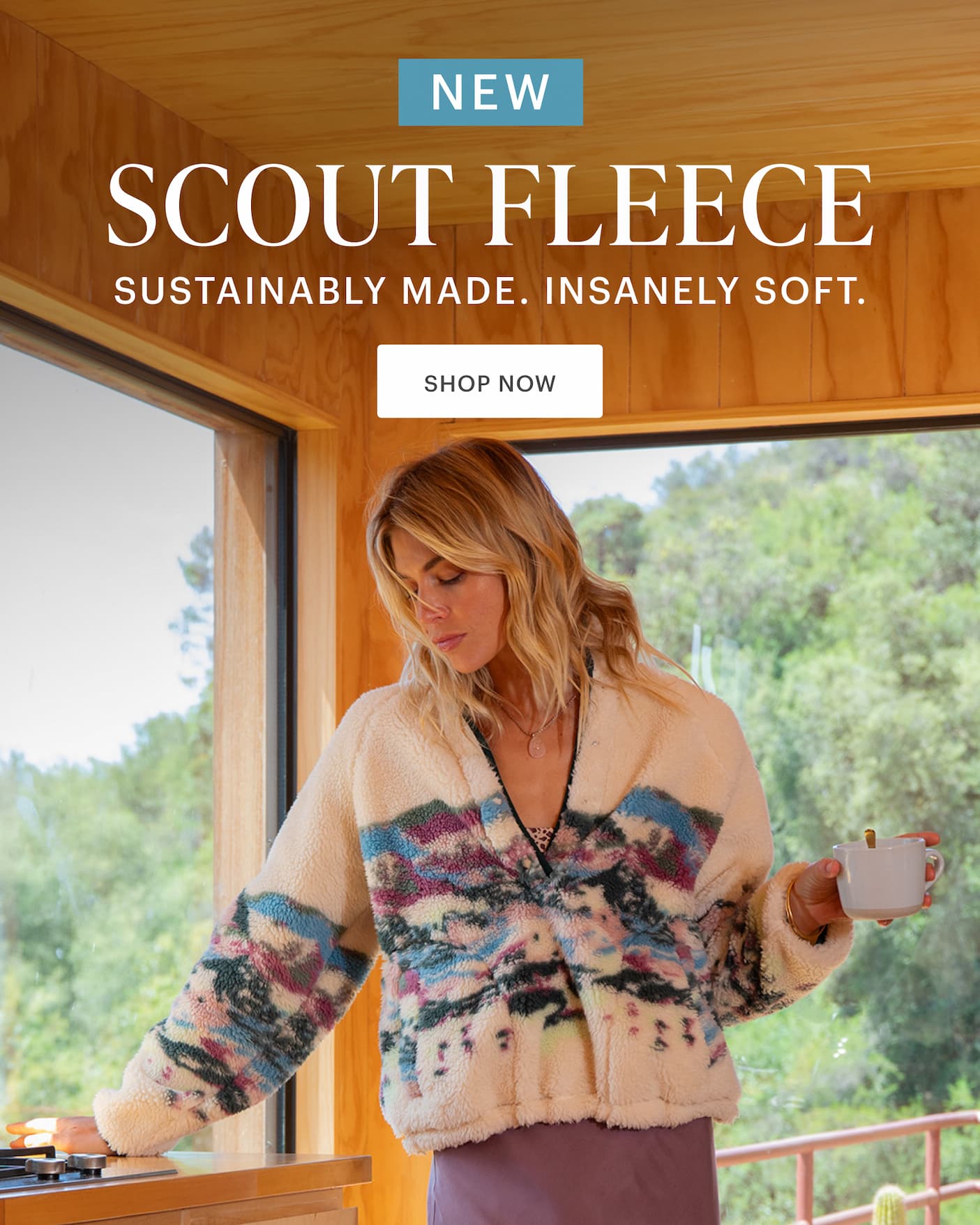 Scout Fleece - Sustainably Made, Insanely Soft. Woman in Scout Fleece Standing by counter in modern wood cabin with woods beyond. 