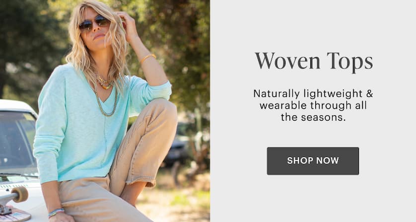 Woman in Amara Sweater and straw hat leaning against classic truck. 