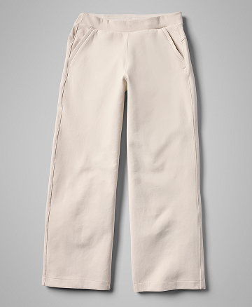 Flatlay of white sweat pants against a grey background.