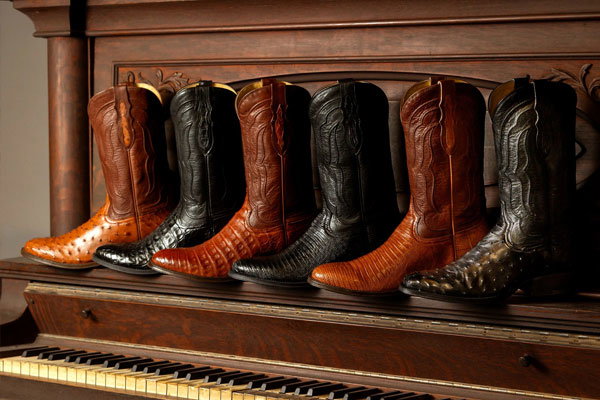 Tony Lama boots lined up on a piano.
