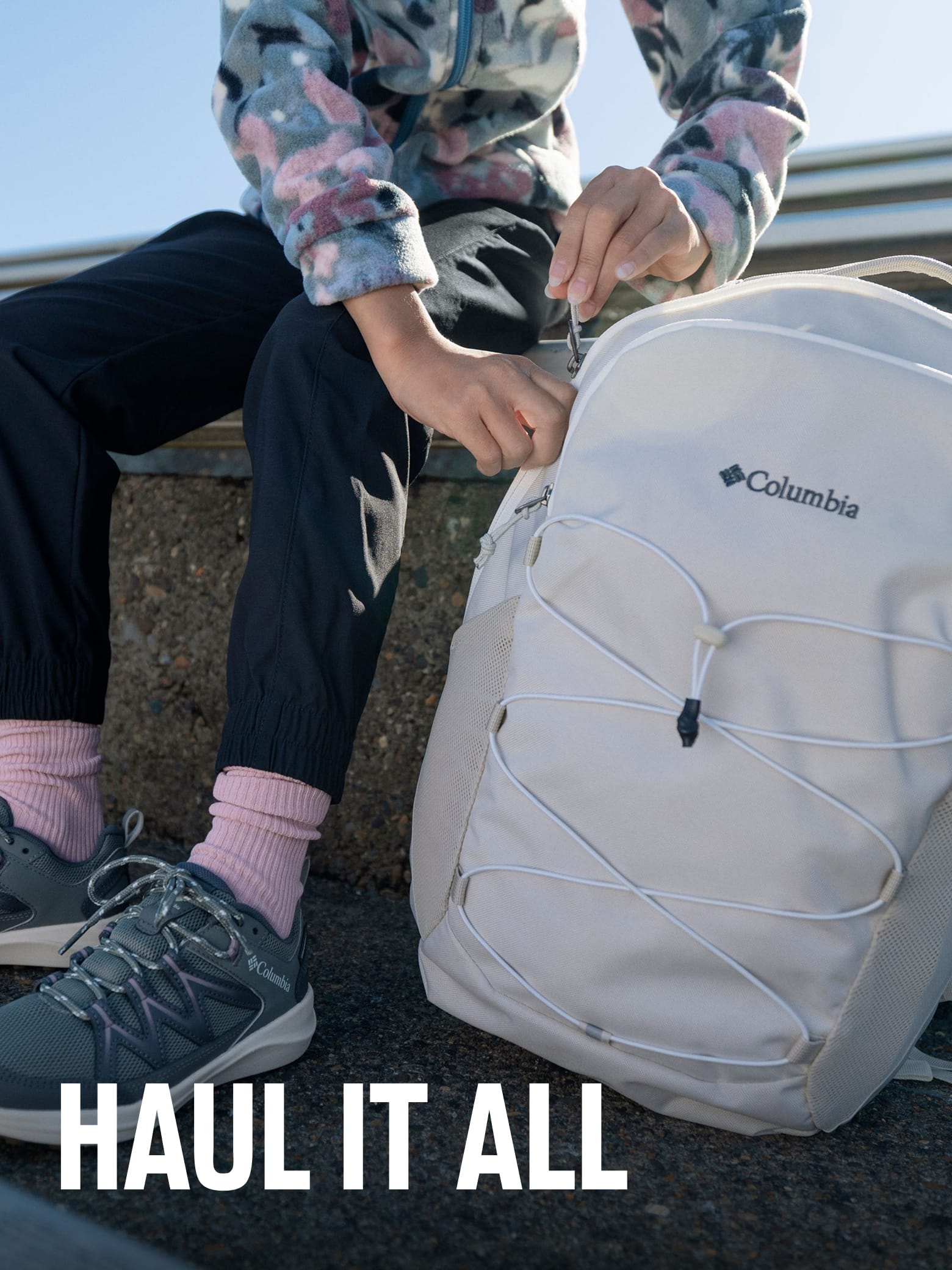 A little girl with a white backpack with text: HAUL IT ALL