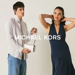 Joven mujer vestida con un vestido azul marino posa mientras un hombre con camisa blanca y vaqueros sostiene un pequeño bolso blanco en una habitación sencilla.