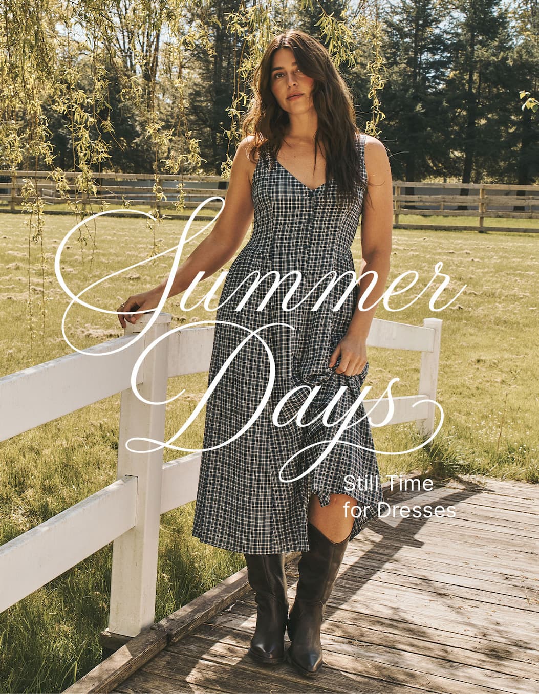 Model wearing a checked midi dress with cowboy boots outdoors. Text: "Summer Days. Still Time for Dresses."
