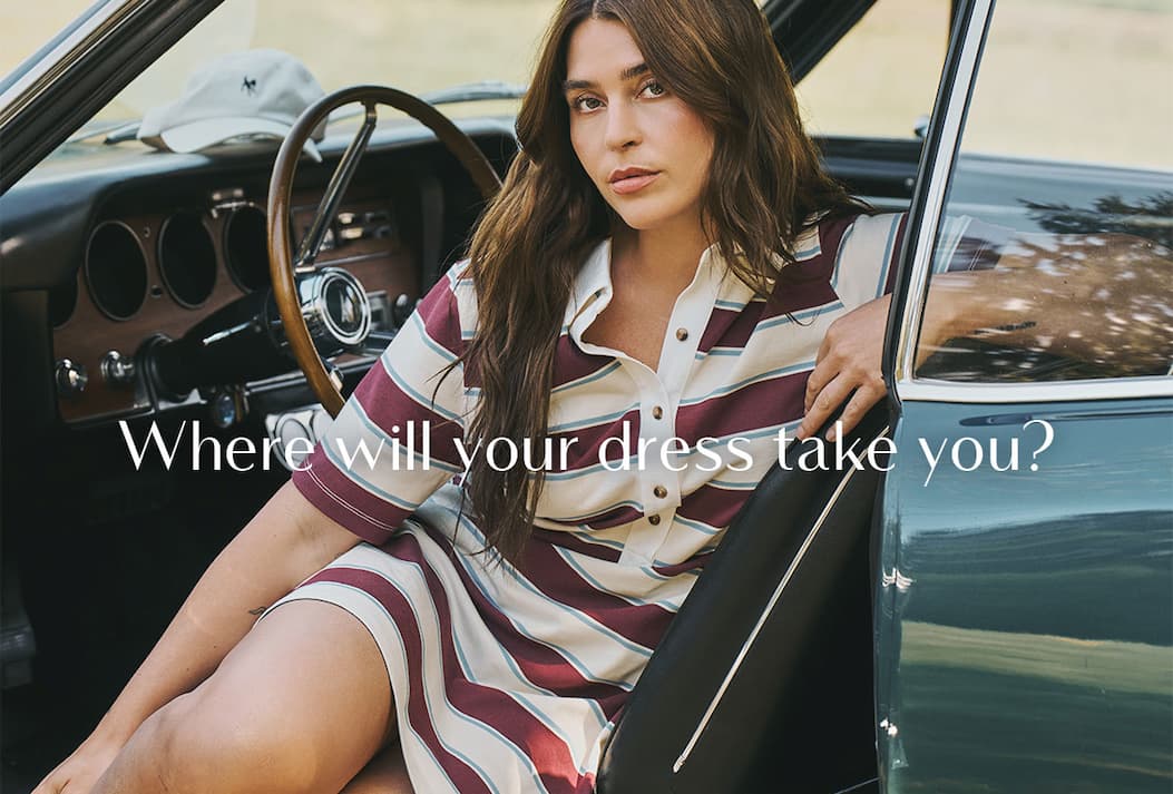 Model wearing a striped polo dress seated in a vintage car. Text: "Where will your dress take you?"