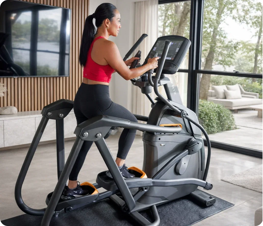Woman exercising on a Matrix Ascent Trainer at home.