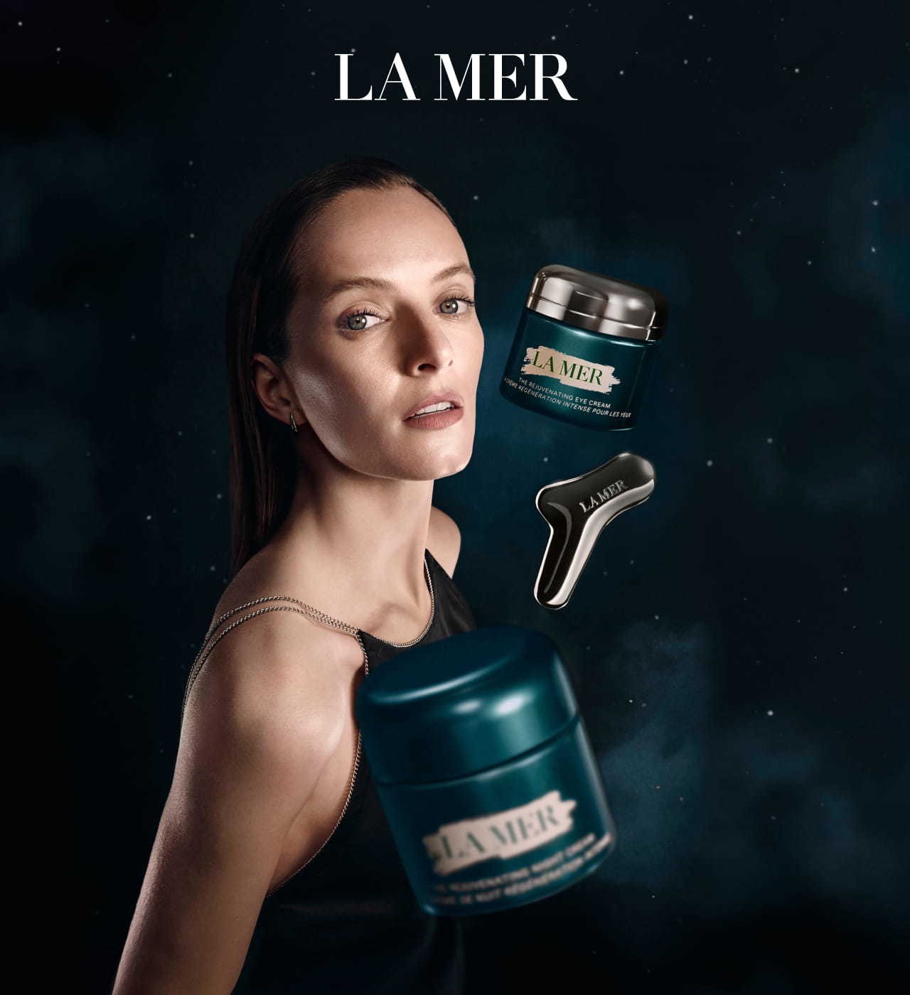 A woman is surrounded by floating jars of The New Rejuvenating Eye Cream and The Rejuvenating Night Cream, against a dark, nebulous background. La Mer logo on top.