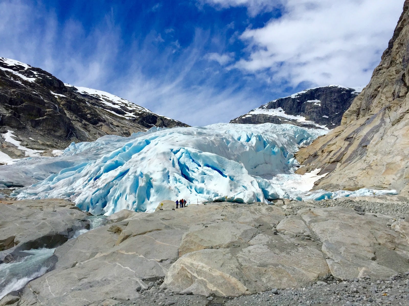 Lengua del glaciar Nigardsbreen con hielo azul y senderistas dando escala a la inmensidad