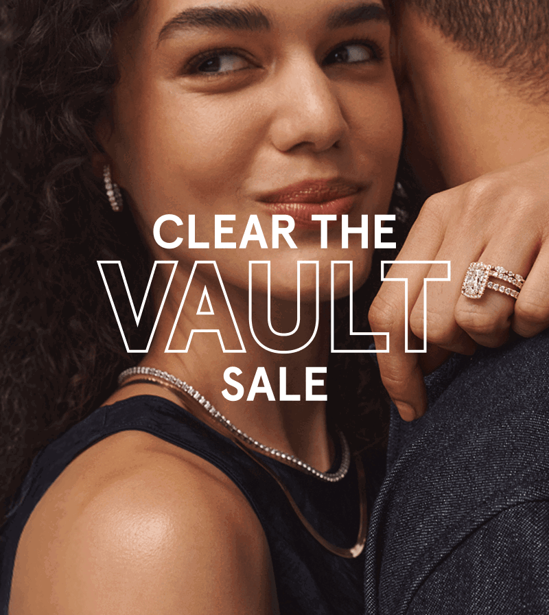 Woman embracing her partner while wearing hoops, necklaces, a diamond tennis bracelet and a ring. Clear the vault sale.