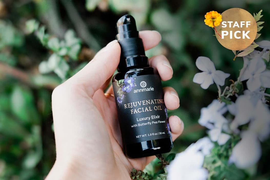Picture of a hand holding the Rejuvenating Facial Oil bottle
