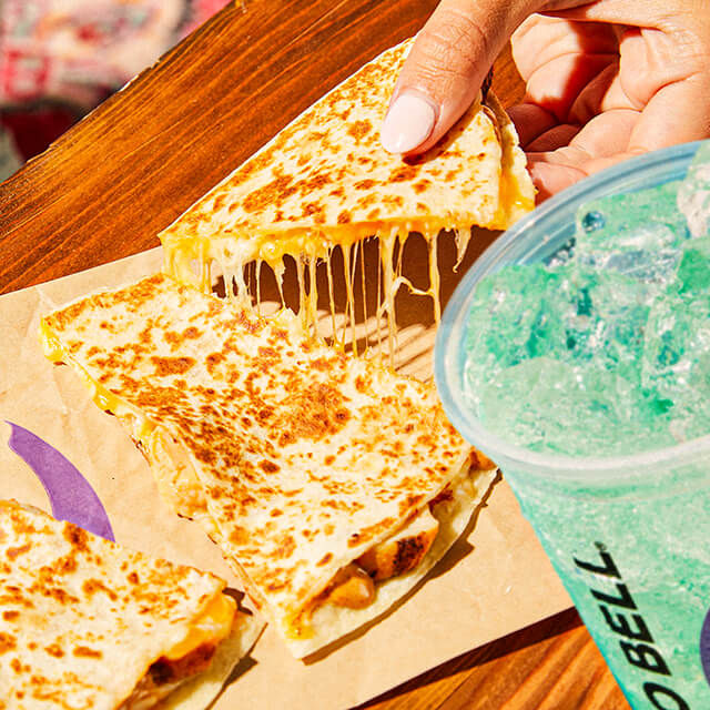 A close-up of a Taco Bell Baja Blast and a Chicken Quesadilla.