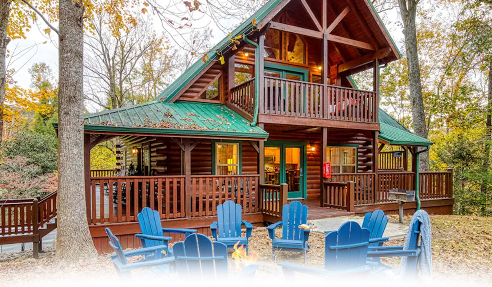 Rustic log cabin with decks, fire pit, and autumn forest setting.